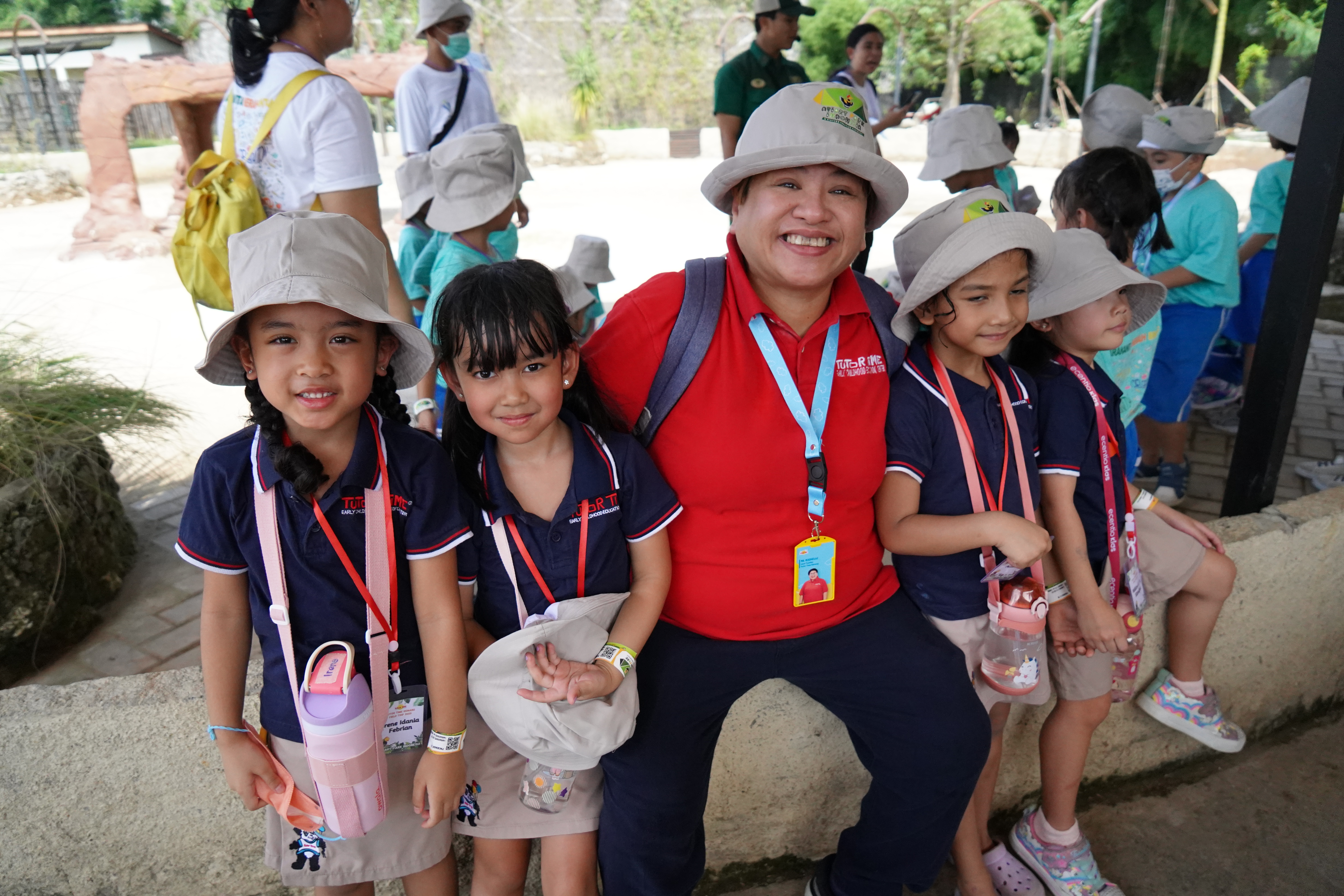 Tutor Time teacher and students on a field trip, smiling together